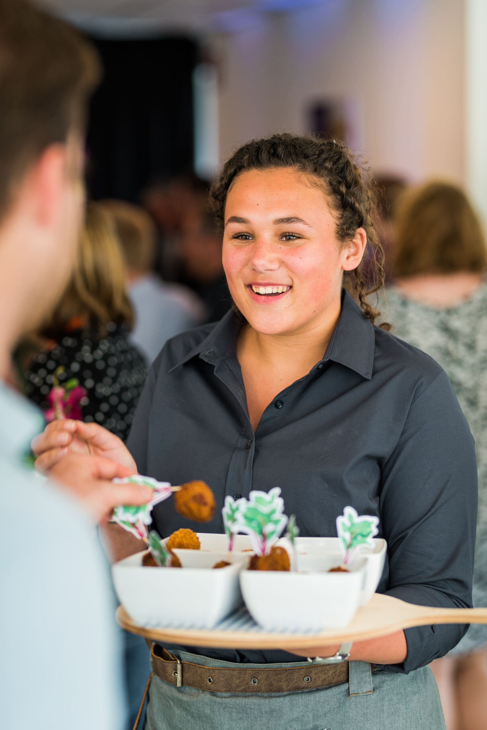 medewerker serveert borrelhapjes uit