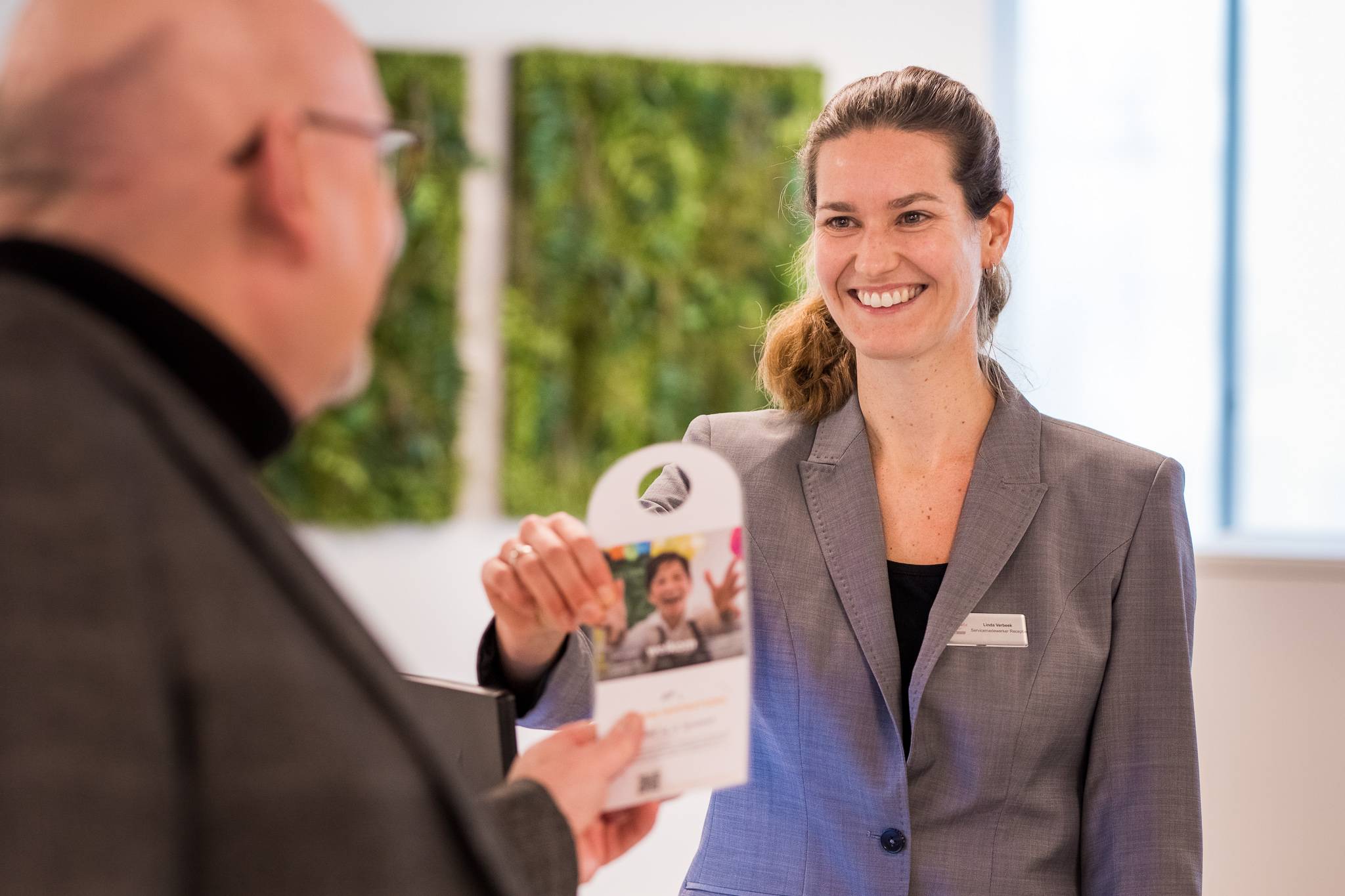 Medewerker overhandigt sleutelkaart aan gast